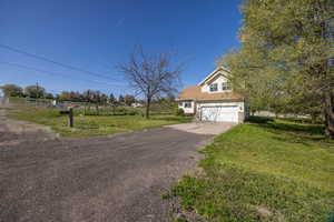 View of front facade with driveway, a front yard, and a garage