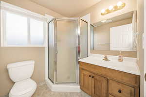 Bathroom with a stall shower, vanity, and light tile patterned floors