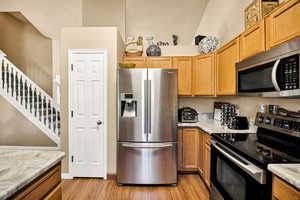 Kitchen with stainless steel appliances, light wood finished floors, and wood finish cabinetry