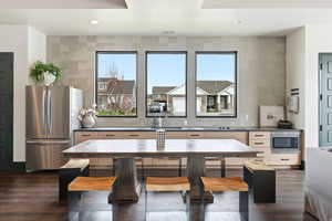 Kitchen with dark countertops, stainless steel appliances, dark wood-type flooring, plenty of natural light, and recessed lighting