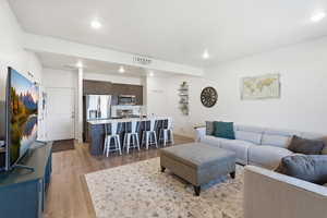 Living room with light wood finished floors and recessed lighting