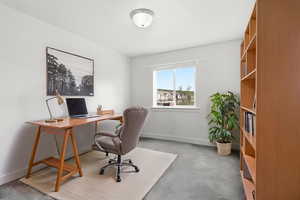 Office space with light carpet and baseboards