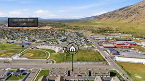 Aerial overview of property's location with nearby suburban area and a mountainous background