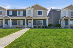 Craftsman-style home with stone siding, a front lawn, and a porch