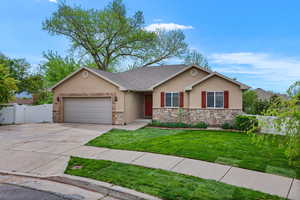 View of front of property featuring a gate, stucco siding, a garage, concrete driveway, and stone siding