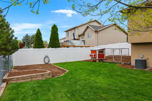 Fenced backyard with exterior structure, a garden, and an outbuilding