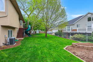 Fenced backyard featuring a playground and stairs