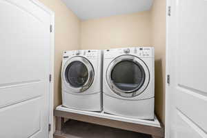 Laundry area featuring washing machine and clothes dryer and a textured ceiling