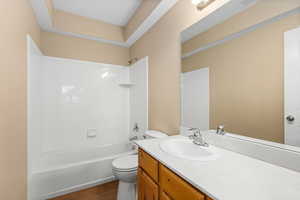 Full bath featuring vanity, shower / tub combination, and dark wood finished floors