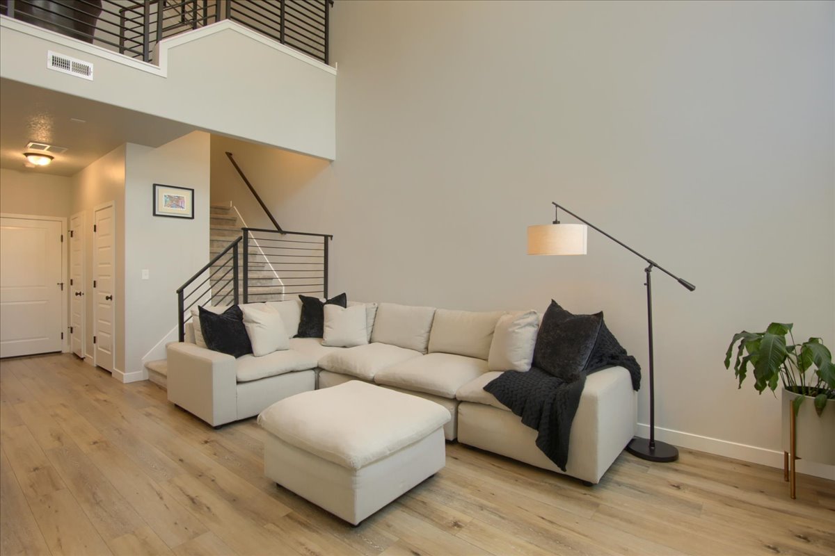 Living area with light wood finished floors and a high ceiling