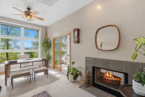 Carpeted living area with a fireplace and ceiling fan