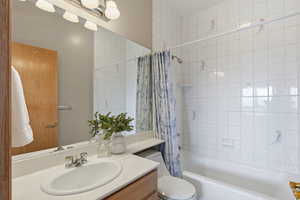 Bathroom with vanity and shower / tub combo with curtain