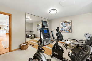 Workout area with baseboards and light colored carpet