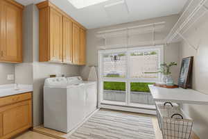 Laundry room featuring cabinet space, baseboard heating, and washer and dryer