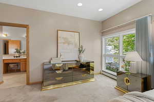 Sitting room with light carpet, baseboard heating, and recessed lighting