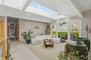 Living area with light colored carpet and recessed lighting