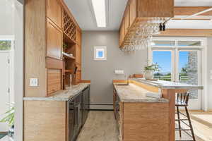 Indoor wet bar with open shelves, beverage cooler, light countertops, and healthy amount of natural light