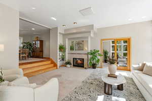 Living room with light carpet and a tile fireplace