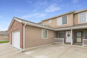 View of home's exterior featuring stucco siding, an attached garage, driveway, and roof with shingles