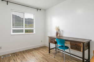 Office with light wood-style floors and baseboards