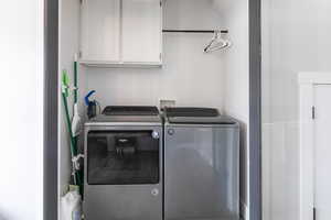 Laundry area with cabinet space and washing machine and dryer
