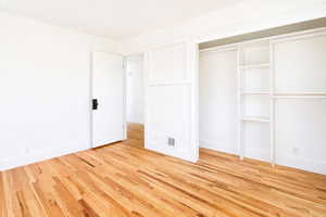 Unfurnished bedroom with light wood finished floors and a closet