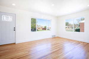 Foyer entrance with light wood-type flooring, healthy amount of natural light, and recessed lighting