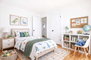(virtual staging) Bedroom with light wood-style flooring and crown molding