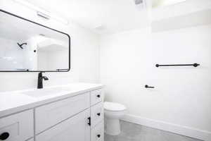 Full bath featuring vanity, a textured ceiling, and a shower