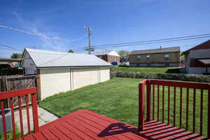 Fenced yard with a wooden deck and an outbuilding