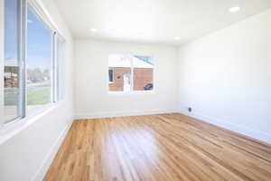 Empty room with light wood-style flooring and recessed lighting