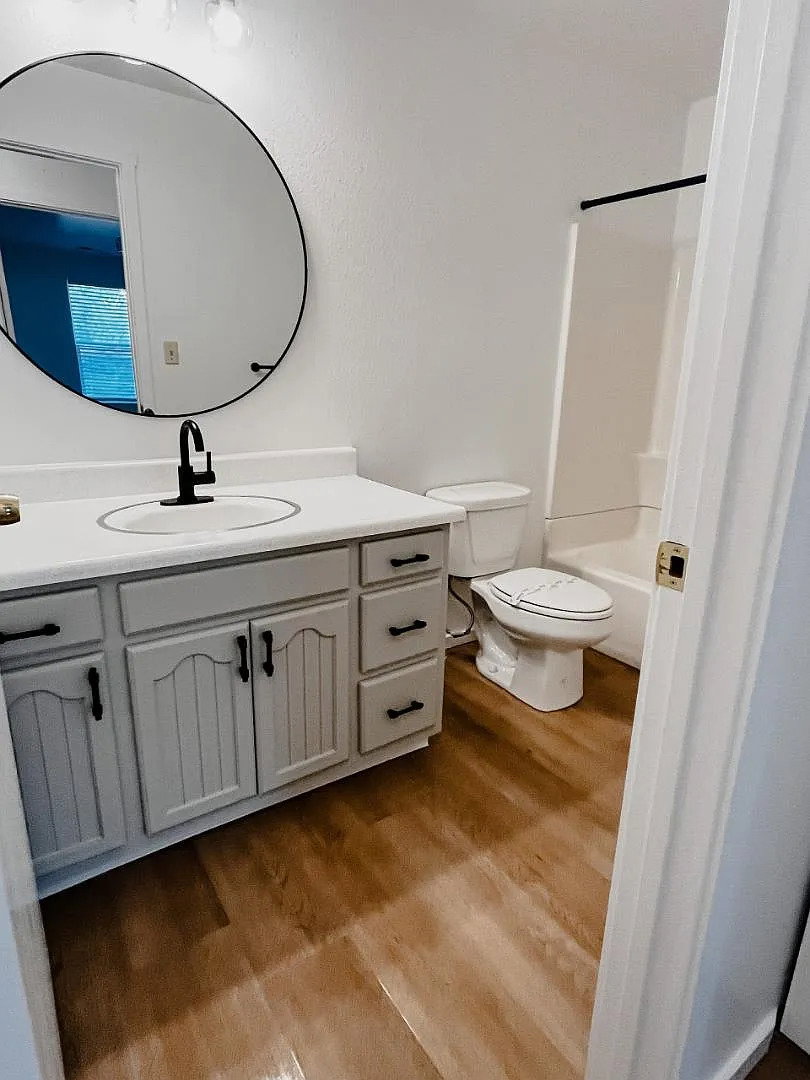 Bathroom with vanity, light wood finished floors, and shower / bathtub combination