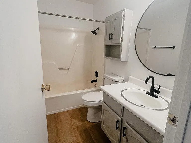 Bathroom with vanity, shower / washtub combination, and dark wood-style floors