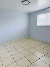 Unfurnished room with light tile patterned floors