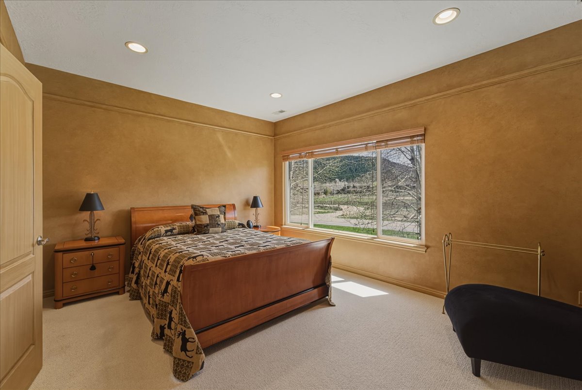 Bedroom featuring recessed lighting, light colored carpet, and a textured wall