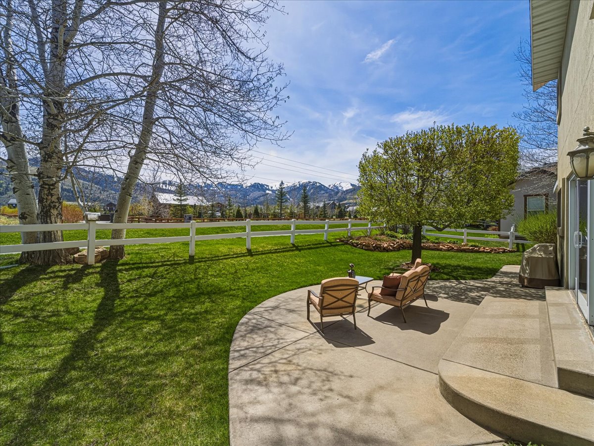 Fenced backyard featuring a patio area and a mountain view