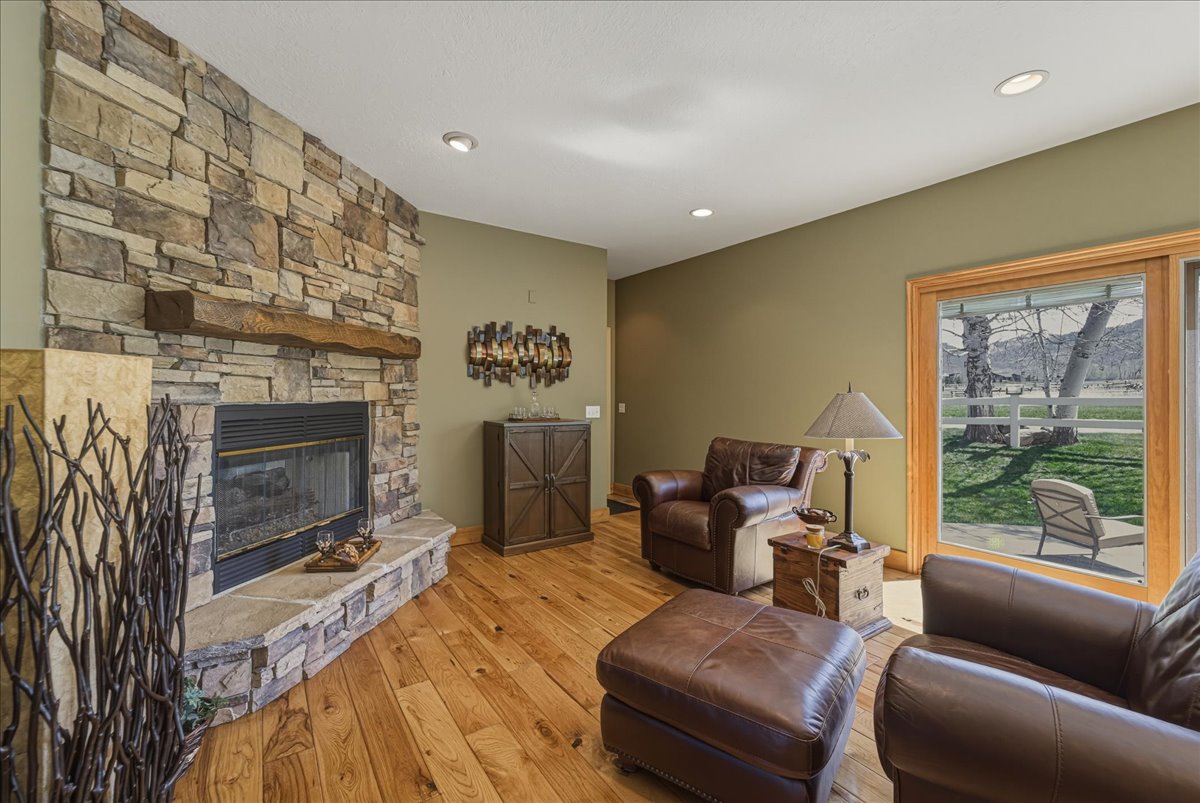 Living room with a fireplace, light wood-type flooring, and recessed lighting