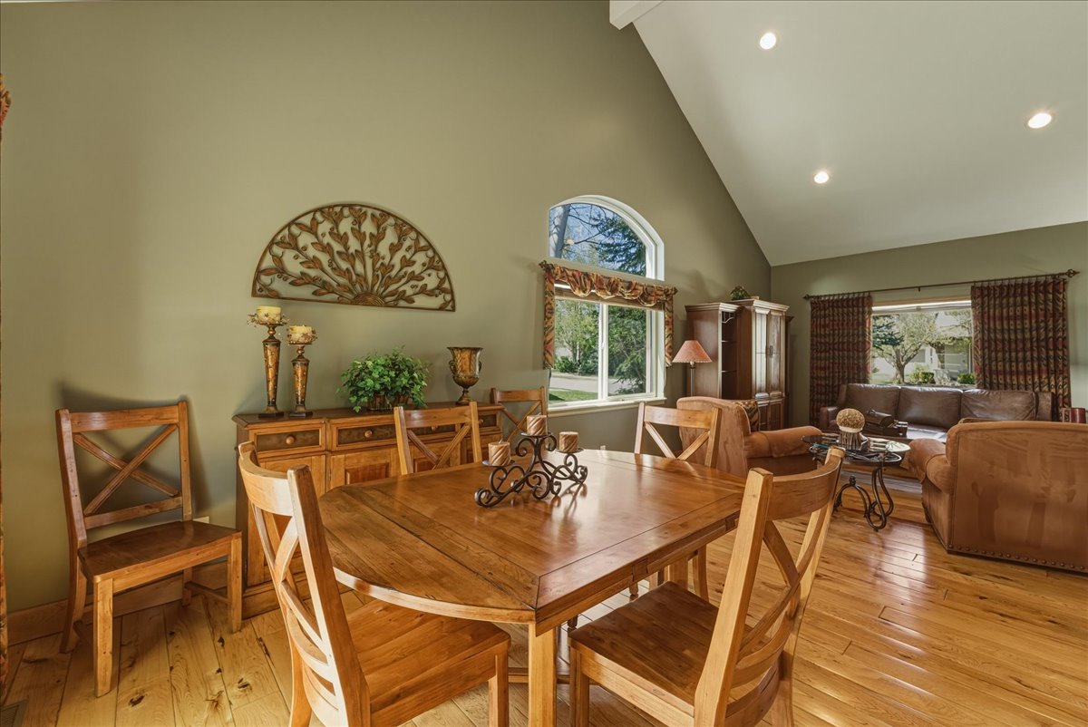 Dining space with light wood-style flooring, vaulted ceiling, and recessed lighting