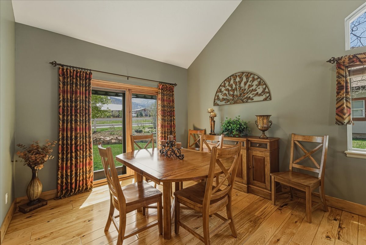 Dining area featuring light wood-style flooring, vaulted ceiling, and healthy amount of natural light