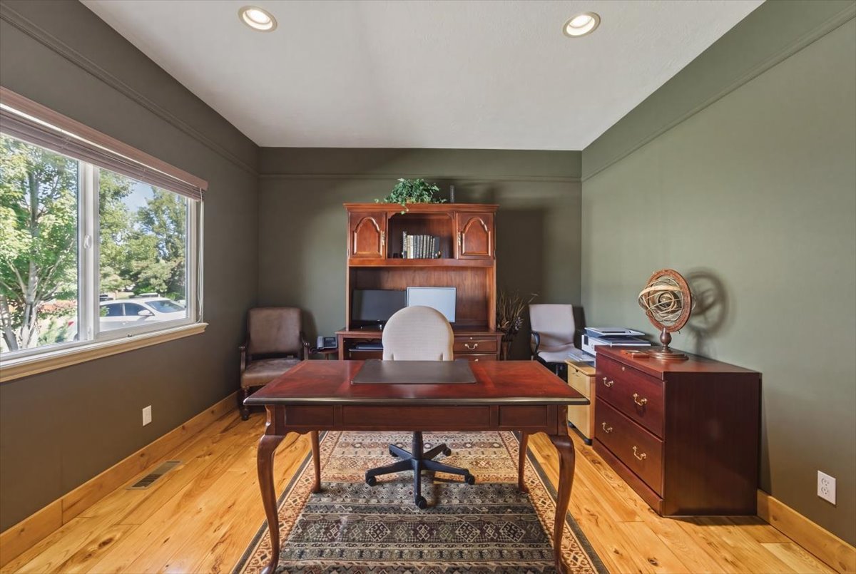 Office with light wood-style floors and recessed lighting