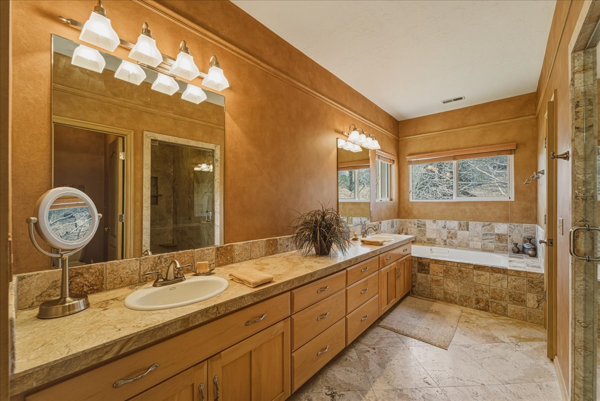 Bathroom with double vanity, a bath, and a shower stall