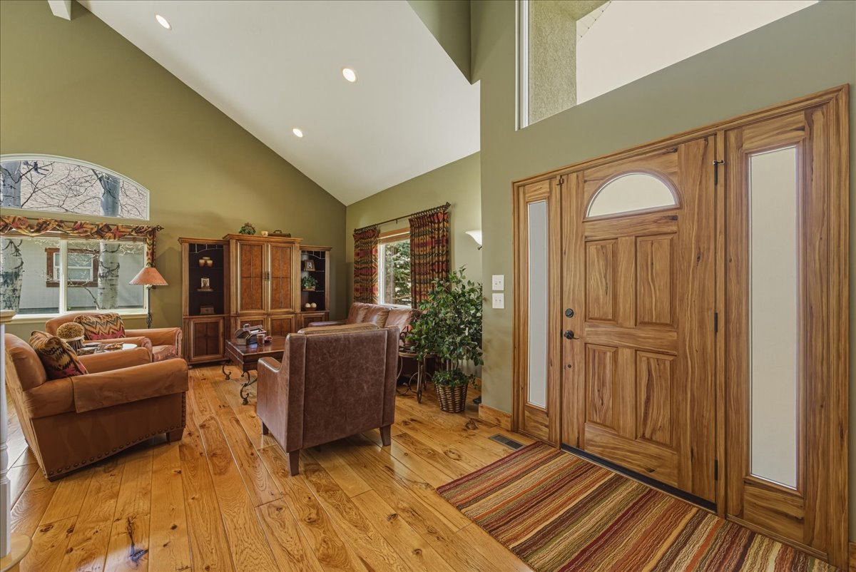 Foyer featuring light wood-style flooring, lofted ceiling, and recessed lighting