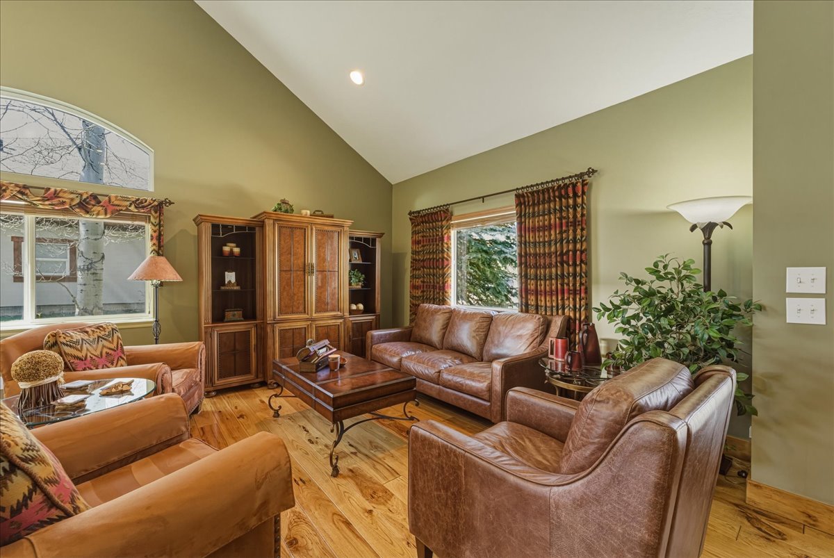 Living area featuring lofted ceiling, light wood finished floors, and recessed lighting