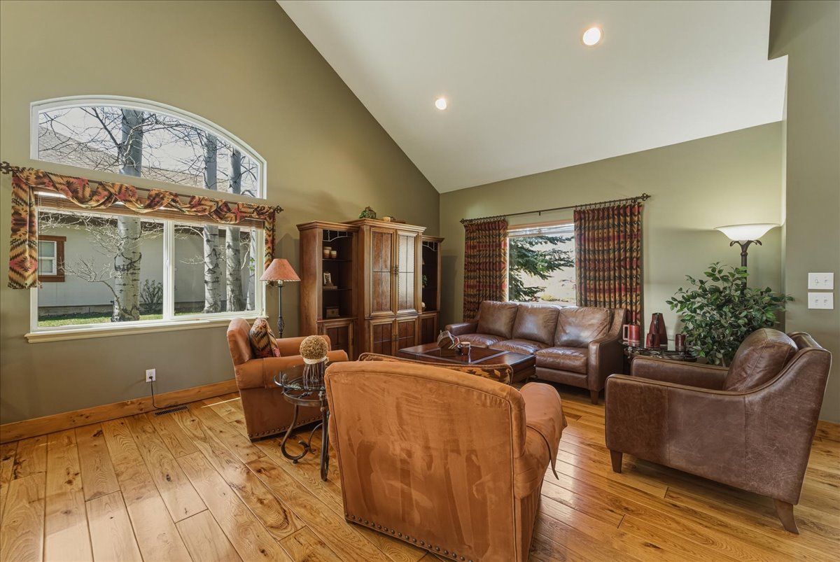 Living area featuring light wood finished floors, vaulted ceiling, and recessed lighting