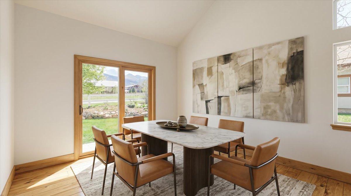 Dining space featuring light wood finished floors and vaulted ceiling