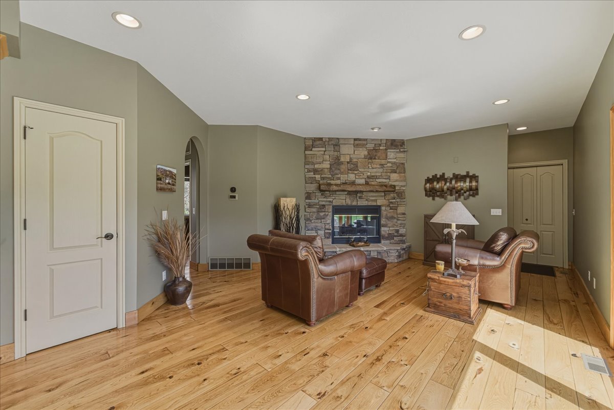 Living room with light wood-type flooring, a fireplace, arched walkways, and recessed lighting