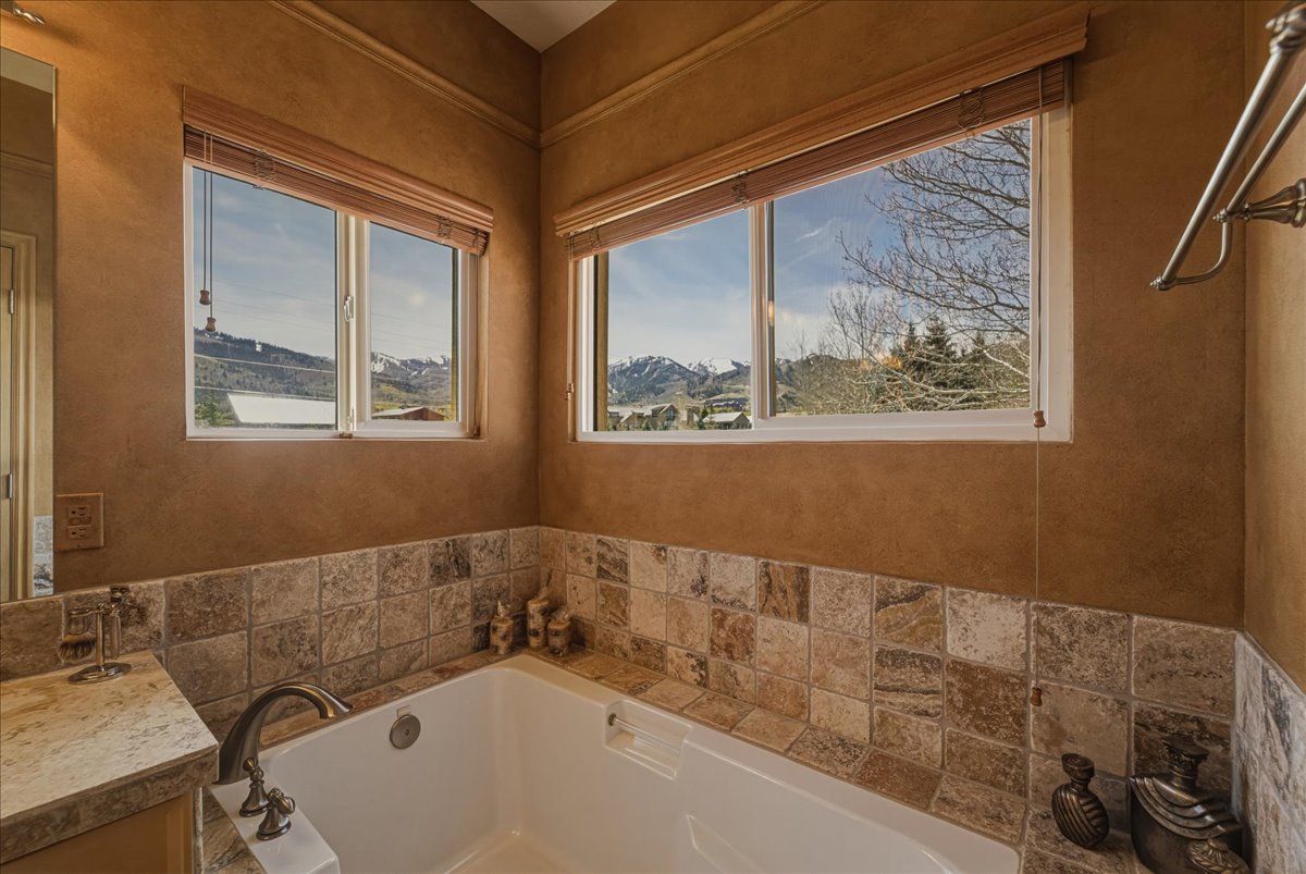 Bathroom with vanity, a bath, and a mountain view