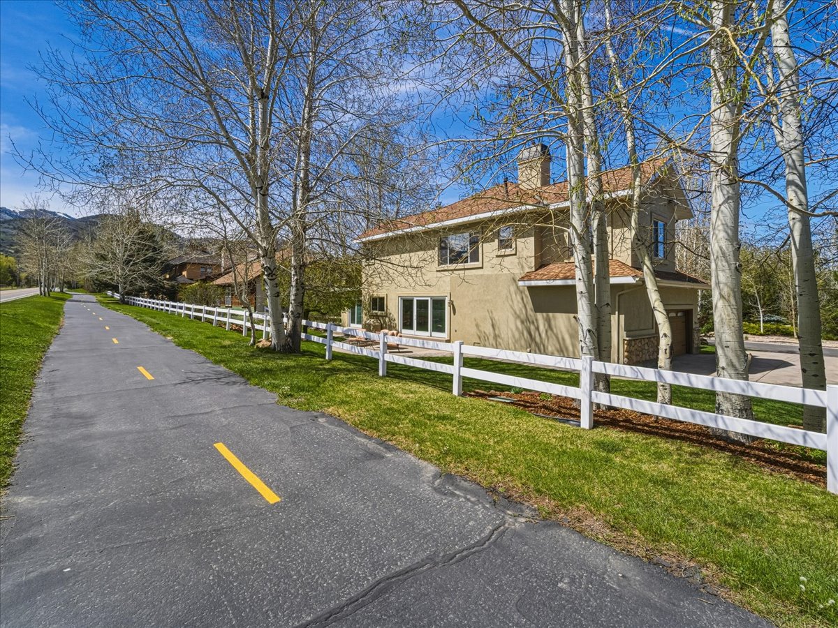View of side of property with a fenced front yard, a chimney, and stucco siding