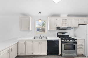 Kitchen featuring stainless steel gas range, light countertops, black dishwasher, crown molding, and decorative light fixtures