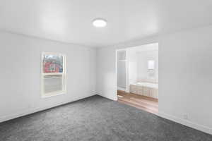 Unfurnished bedroom featuring light colored carpet and connected bathroom